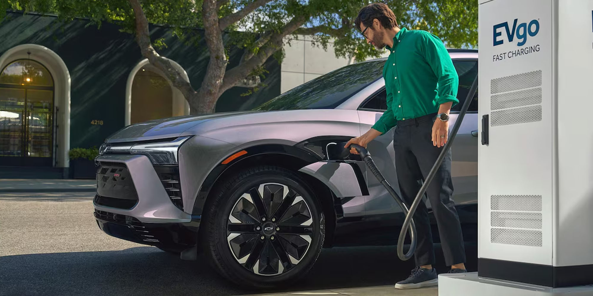 Hombre recargando su vehículo eléctrico Chevrolet.